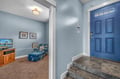 Step into your welcoming coastal retreat through the charming blue front door. Cozy seating awaits with ocean-themed decor and TV for relaxing evenings.