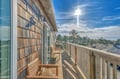 Sun-drenched wooden balcony with teak furniture where you'll savor morning coffee while enjoying views over the neighborhood's charming rooftops.