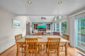 Gather around this warm dining table for meals while enjoying the open living space and forest views beyond.