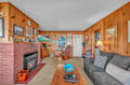 Cozy up in your charming wood-paneled living room, complete with a warming fireplace and comfortable seating for relaxing evenings.