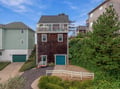 This charming coastal property features a top-floor balcony where you can enjoy ocean breezes and panoramic views. Nestled among neighboring homes and lush greenery, it offers a peaceful retreat with easy access to local beach attractions.