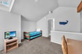 Your kids will love this charming attic bedroom with skylight, TV entertainment, and playful whale decor creating the perfect retreat.