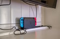 A Nintendo Switch sits ready for your downtime, connected to the wall-mounted TV for cozy gaming sessions during your stay.