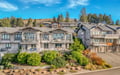Modern coastal homes nestled among evergreen trees offer a peaceful retreat in this scenic residential development.