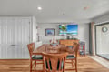 Gather around this warm wooden dining table where nautical touches and coastal artwork create the perfect setting for your memorable meals together.