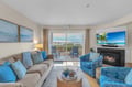 Unwind in this coastal-inspired living room where ocean blues meet comfort. Your private balcony overlooks serene waters while the fireplace adds warmth to cozy evenings.