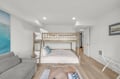 Your cozy beach-themed room features a bunk bed with a full mattress below, perfect for families, plus a comfy sofa and airy, sunlit space for ultimate relaxation.