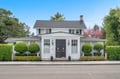 Charming white colonial home with manicured landscaping and welcoming front entrance in a peaceful residential setting.
