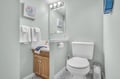 Your private bathroom features a well-lit vanity, fresh towels, and cheerful artwork to brighten your morning routine.