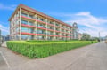 Multi-story property building with balconies and landscaped grounds provides a welcoming arrival experience.
