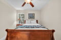 Drift off peacefully in your cozy bedroom featuring rich wood furnishings, crisp linens, and thoughtful touches like bedside lighting.