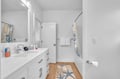 Step into your pristine bathroom featuring a spacious tub, modern vanity, and coastal touches that create a spa-like retreat.