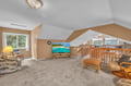 Unwind in your spacious loft living area with tropical-themed seating, large TV for movie nights, and charming slanted ceilings that create a cozy retreat.