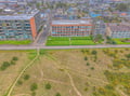 Aerial view showcasing the property's prime coastal location, with direct access to scenic walking paths and nearby residential neighborhood.