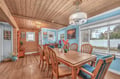 Gather around this beautiful dining table where warm wood meets coastal charm. Natural light floods your meal times through oversized windows.