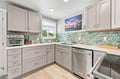 Step into a beautiful kitchen where cooking feels effortless. Gleaming white countertops, coastal-inspired backsplash tiles, and modern stainless-steel appliances create your home-away-from-home. Natural light streams in as you prep meals in style.