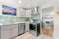 Step into your fully equipped kitchen with modern stainless appliances, elegant aqua tilework, and bright open space—perfect for whipping up your favorite meals during your stay.