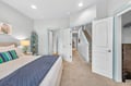 Sink into your plush bed in this coastal-inspired bedroom featuring a walk-in closet and stylish beach decor.