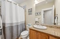 Step into your private bathroom with its cheerful decor, warm lighting, and fresh towels waiting for you—a welcoming space to refresh after a day of adventure.