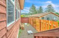 Step outside to your private gravel patio with a wooden fence and small seating area, surrounded by tall pines and mountain views—perfect for morning coffee or evening relaxation.