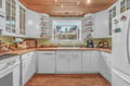 Cook your favorite meals in this bright, fully-equipped kitchen with wood countertops, open shelving for your treasures, and a garden window.