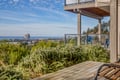 Modern coastal property with balconies overlooking Pacific City and Haystack Rock. Contemporary architecture surrounded by natural landscape.