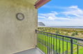 Coastal retreat balcony showcasing endless ocean views and rolling green landscape beyond manicured grounds.