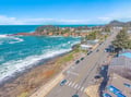 Stunning aerial view of coastal town with dramatic oceanfront cliffs, pristine beaches, and charming neighborhoods nestled along the scenic Pacific coastline.