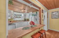 Gather around this charming kitchen island where warm wood meets coastal style, creating your perfect space for morning coffee and evening conversations.
