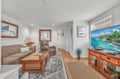 Unwind in your cozy living room with comfortable seating, large TV, and tropical beach scenes that transport you to paradise.
