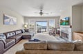 Unwind in your spacious living room with plush leather seating, cozy fireplace, and private balcony overlooking scenic water views.