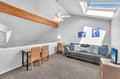 Relax in your bright attic retreat with skylight views, cozy seating, and workspace perfect for unwinding after coastal adventures.