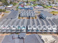 Aerial view of the property complex showing multiple vacation rental units arranged in rows with the surrounding coastal town neighborhood.