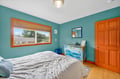 Unwind in your bright bedroom with ocean-blue walls, natural light, and charming coastal touches that create a peaceful retreat.