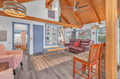 Relax in this charming open-concept living space featuring rustic wood beams, cozy leather seating, and thoughtful coastal touches throughout.