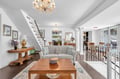 Relax in your elegant living room with plush seating, warm wood accents, and sparkling chandeliers creating the perfect atmosphere for unwinding.