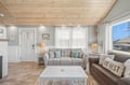 Settle into your coastal retreat with soft grey sofas, beachy accents, and warm wood ceilings that create the perfect space to unwind after exploring the shore.
