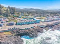 Dramatic coastline meets charming town in this scenic location, featuring rugged cliffs and forested hills surrounding the community.