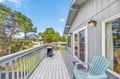Spacious deck with comfortable seating where you can relax while enjoying treetop views and fresh coastal air.