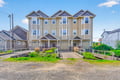Modern coastal townhome complex featuring distinctive architecture and landscaped grounds in a charming neighborhood setting.