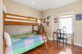 Your comfortable bunk room offers a perfect retreat for the kids, with cheerful bedding, warm wood floors, and a cozy desk by the window for quiet reading or drawing.