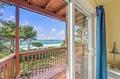 Step through the glass door onto your private deck and breathe in the coastal air—waves rolling in, pine trees framing the horizon, and the ocean stretching endlessly before you.