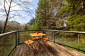 Your private balcony overlooks lush forest views, where morning coffee tastes better at this bright orange bistro set.