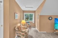 Relax in your cozy reading nook with comfortable seating, warm natural light, and peaceful garden views through the window.