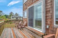 Step onto your private deck where coastal comfort meets relaxation—sink into weathered Adirondack chairs and breathe in the sea breeze.