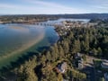Stunning aerial perspective showcasing the coastal town, iconic bridge, and forested waterfront setting of this peaceful retreat destination.