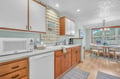 Your fully equipped kitchen awaits with warm wood cabinets, modern appliances, and charming brick backsplash, perfect for cooking memorable meals.