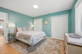 Wake to soft natural light in your calming coastal-inspired retreat, where plush bedding and soothing turquoise walls invite restful sleep and peaceful mornings.