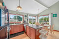 Your bright kitchen flows seamlessly into the dining area, where morning coffee tastes better with peaceful views through large windows.