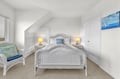 Your coastal bedroom retreat awaits with white wicker furnishings, soft lighting, and nautical touches that promise peaceful nights by the sea.